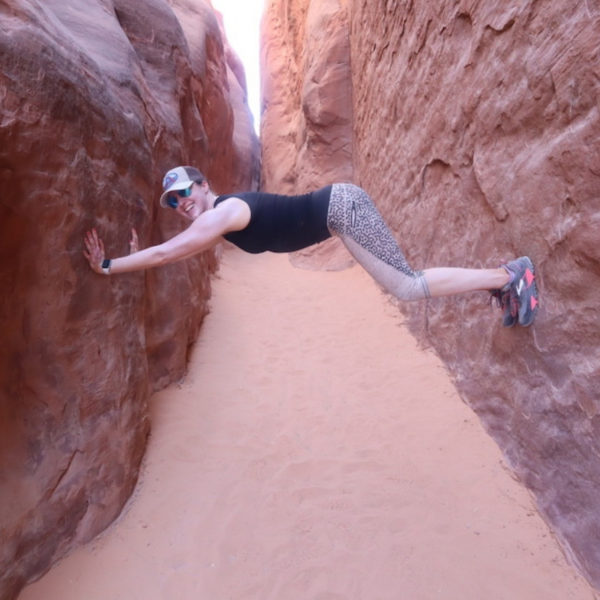 Isabel holding herself up on rocks in Moab