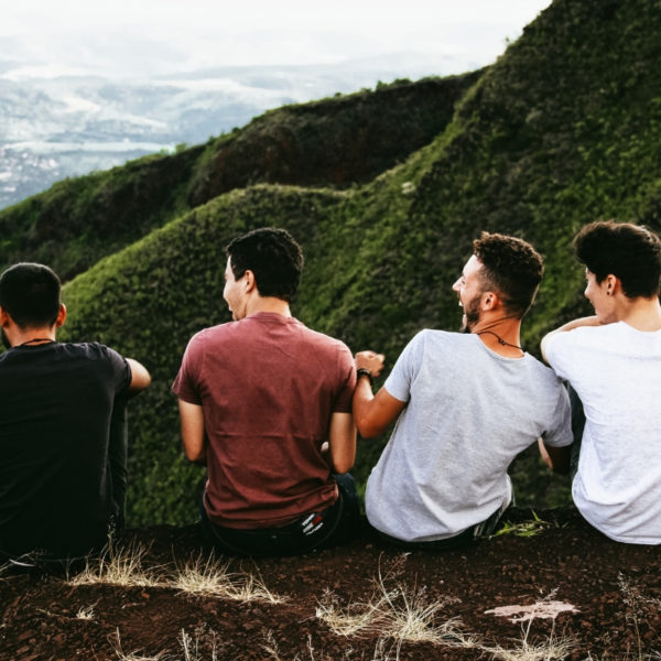 Guys sitting on a hill laughing